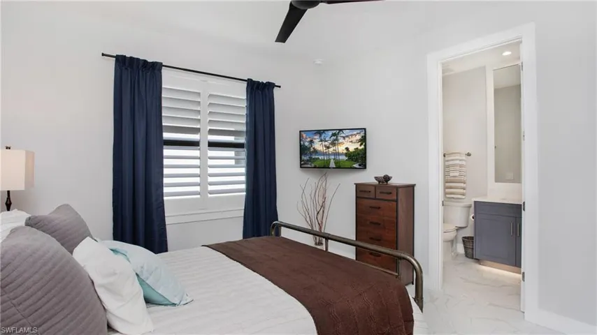 Bedroom featuring ensuite bathroom and ceiling fan