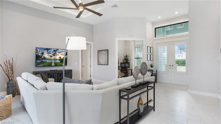 Living room featuring a high ceiling and ceiling fan