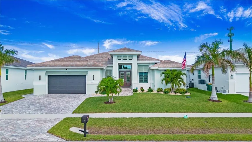 View of front of property featuring a garage, central AC, and a front yard