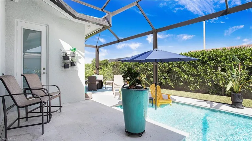 View of swimming pool featuring glass enclosure and a patio area
