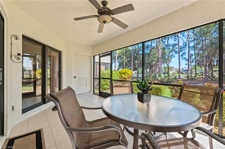 Lanai with view of lake, landscaping and trees.