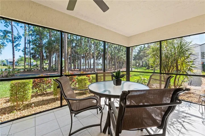 Lanai with view of lake, landscaping and trees.