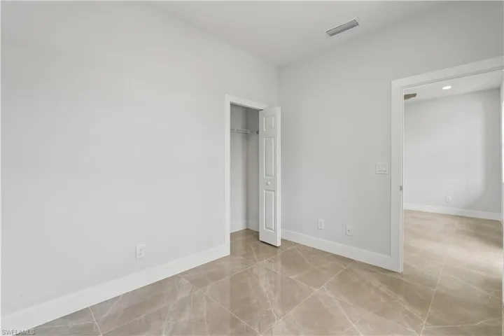 Unfurnished bedroom featuring light tile patterned floors, a closet, and recessed lighting