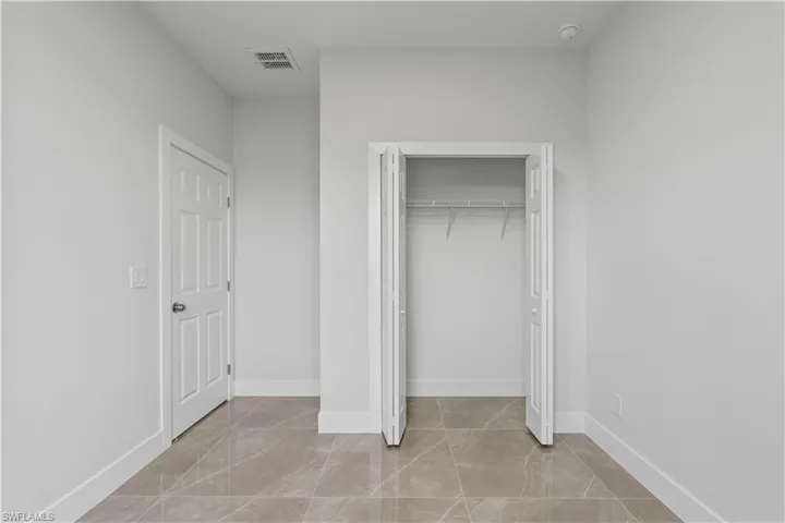 Unfurnished bedroom featuring a closet and light tile patterned floors