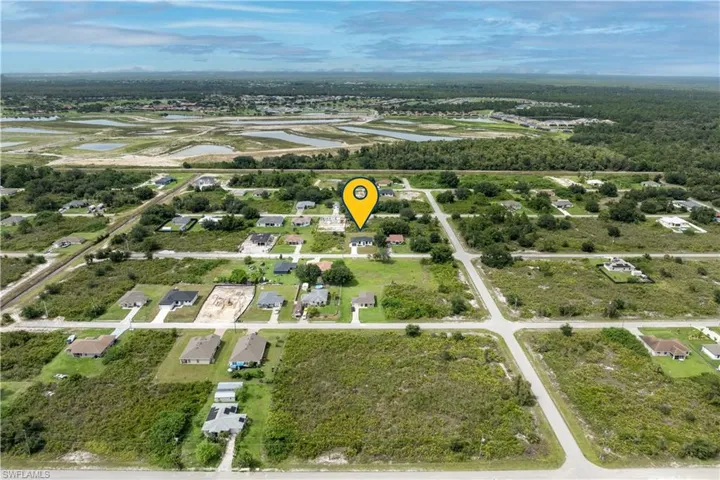 Aerial view of property and surrounding area featuring nearby suburban area and a large body of water