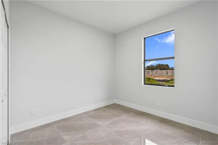 Unfurnished room featuring baseboards and light tile patterned flooring