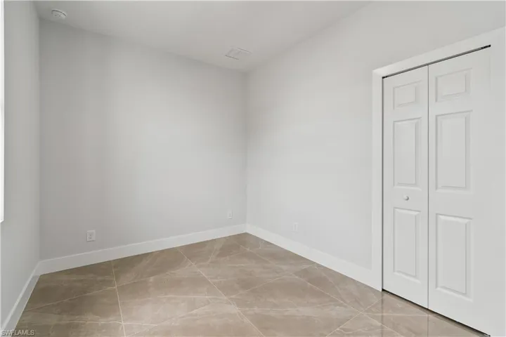Unfurnished bedroom featuring a closet and light tile patterned floors