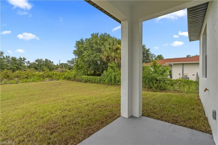 View of grassy yard featuring a patio area