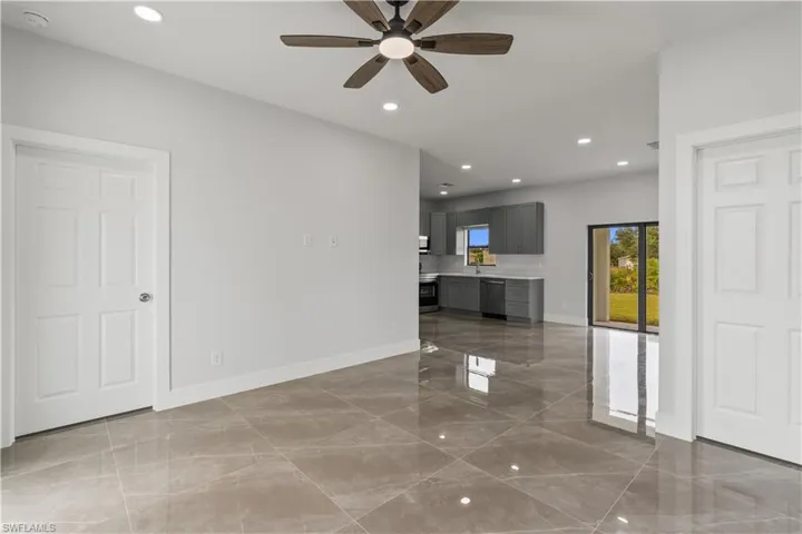 Unfurnished living room with recessed lighting, a ceiling fan, and dark marble finish flooring