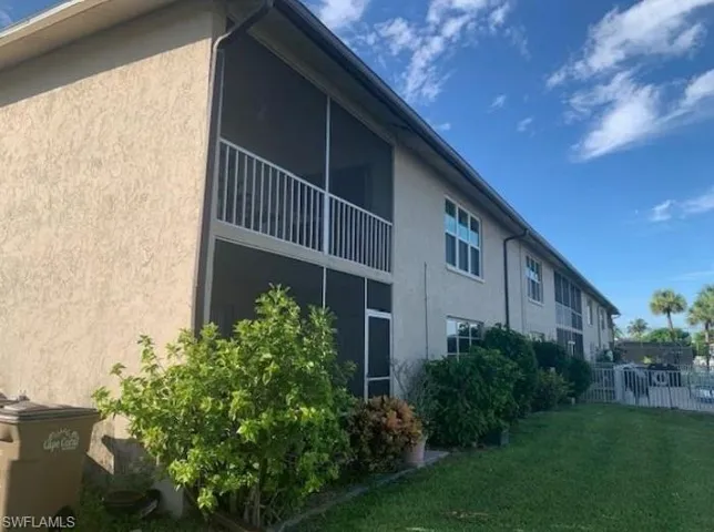 View of property exterior featuring a sunroom, stucco siding, and a balcony