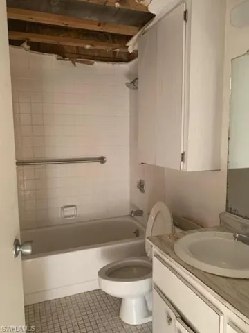 Full bath featuring bathtub / shower combination, vanity, and light tile patterned floors