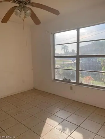 Spare room featuring light tile patterned floors and a ceiling fan
