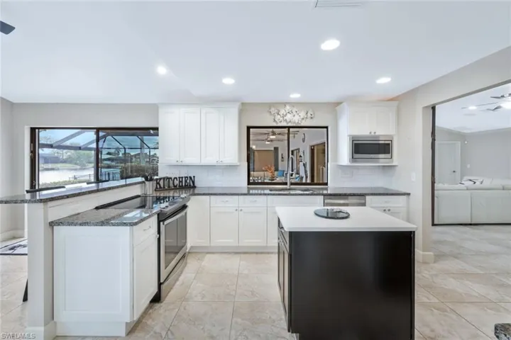 Kitchen featuring stainless steel appliances, white cabinetry, tasteful backsplash, and sink