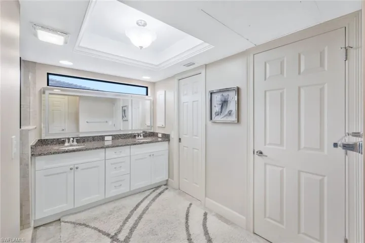 Bathroom featuring a tray ceiling and vanity