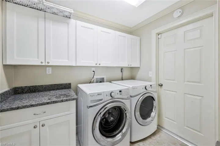 Laundry area with cabinets, washer and dryer, and crown molding