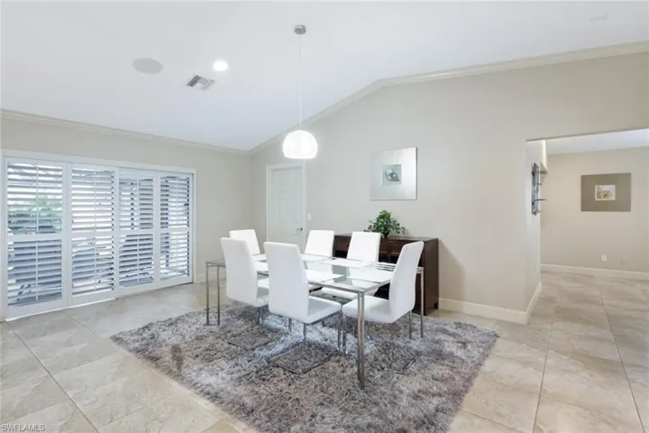 Dining area with ornamental molding and vaulted ceiling