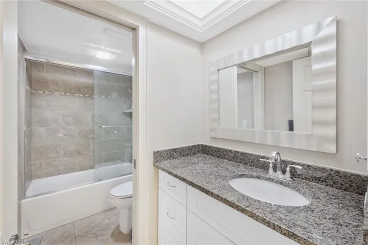 Full bathroom featuring vanity, toilet, and shower / bath combination with glass door