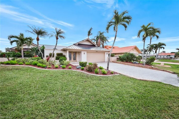 View of front of property with a front yard and a garage