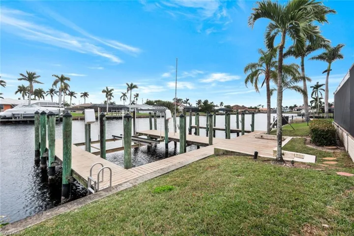 Dock area with a lawn and a water view