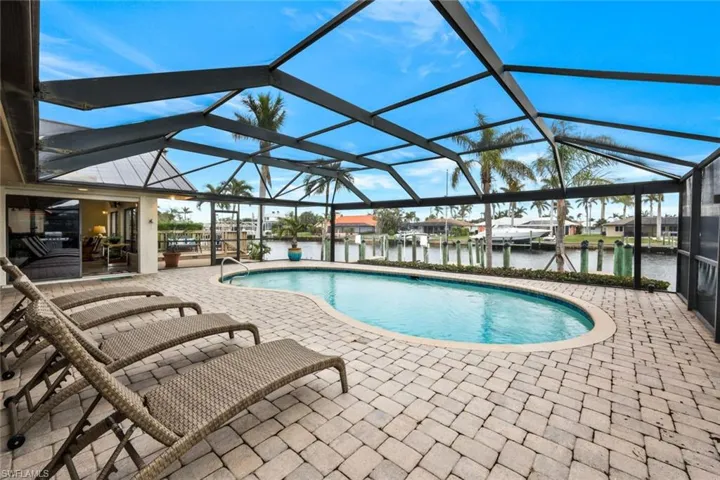 View of pool featuring a water view, a patio area, and a lanai