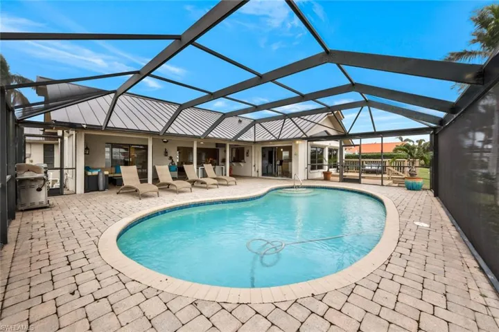 View of swimming pool featuring a patio area and a lanai