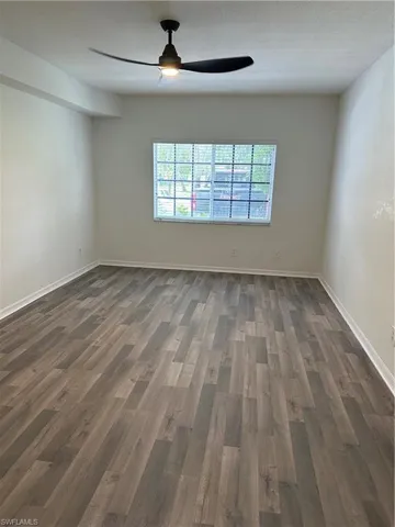 Spare room featuring a textured ceiling, ceiling fan, and dark hardwood / wood-style floors
