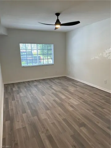 Unfurnished room with a textured ceiling, dark wood-type flooring, and ceiling fan
