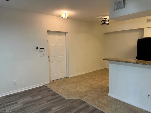 Kitchen featuring black fridge and wood-type flooring