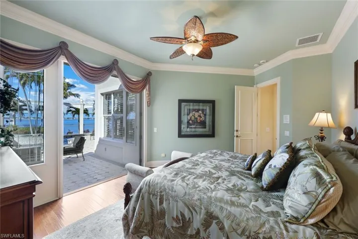 2nd of the 1st floor Bedrooms with ensuite bathroom, large closet with access to exterior, through beautiful French doors, ceiling fan, crown molding, a river view, a pool view and an outdoor firepit.  Just walk out to your private beach from here!