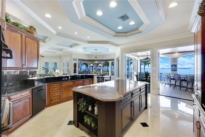 Kitchen featuring a wealth of natural light, crown molding, a kitchen island, and black dishwasher