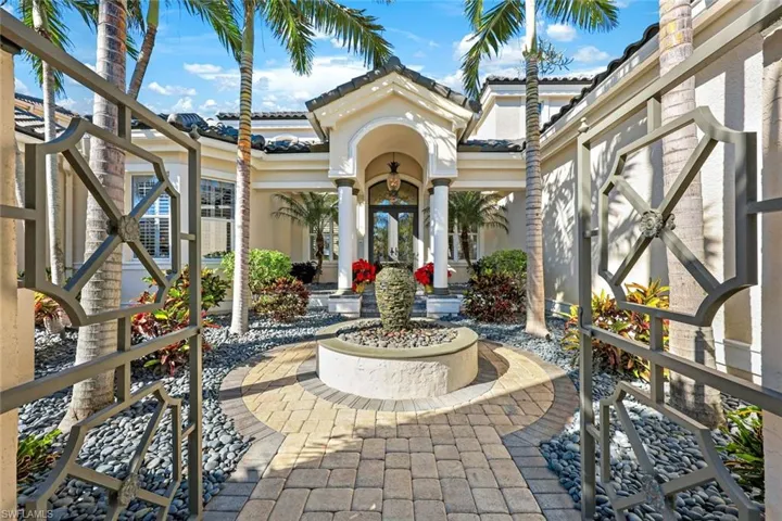 Enter through this remarkable terrace of this spectacular home featuring a waterfall, gorgeous stone work and landscaping,  front gates and lights accents to illuminate the features of this elegant entry.