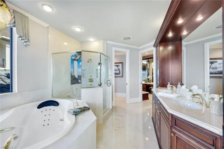 Bathroom with vanity, crown molding, and independent shower and bath
