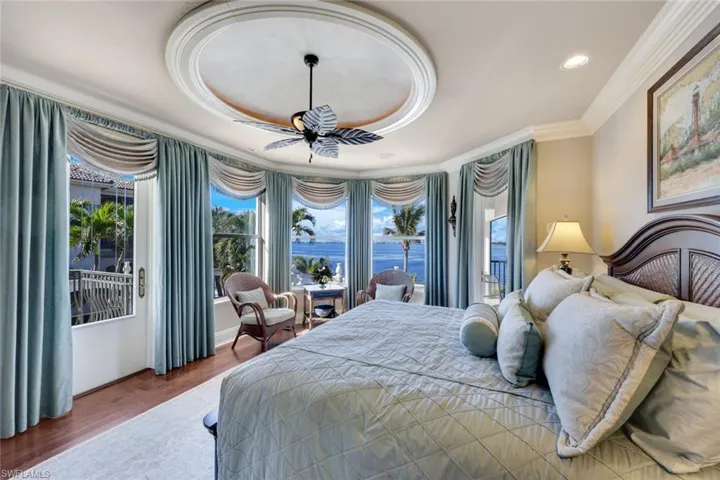 This 2nd Floor owners suite includes a Balcony, a lanai and a sun deck! Featuring  dark hardwood / wood-style flooring, ornamental molding, 2 ceiling fans, and a water view of the river.
