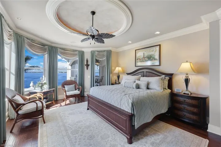 This 2nd Floor owners suite includes a Balcony, a lanai and a sun deck! Featuring  dark hardwood / wood-style flooring, ornamental molding, 2 ceiling fans, and a water view of the river.