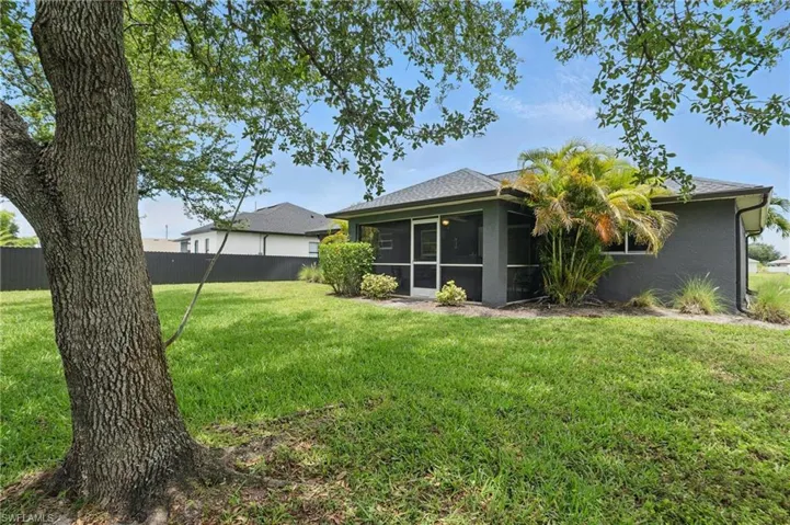 Rear view of property featuring a sunroom, stucco siding, and roof with shingles