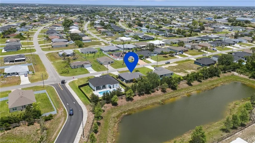 Aerial view of property and surrounding area featuring a large body of water and nearby suburban area