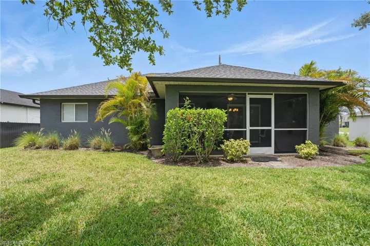 Rear view of property with a yard, a sunroom, and roof with shingles