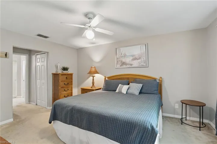 Bedroom featuring light carpet, a closet, baseboards, and ceiling fan