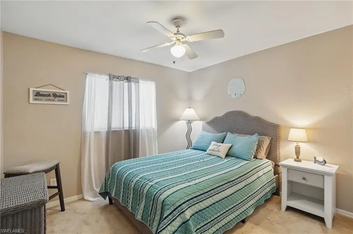 Carpeted bedroom with baseboards and a ceiling fan