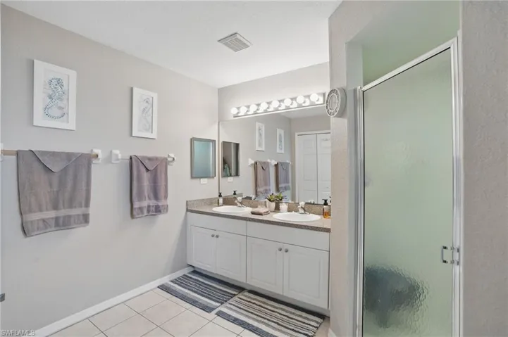 Bedroom with light colored carpet, baseboards, and ceiling fan