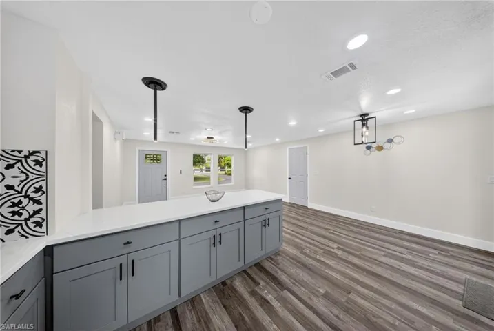 Kitchen island with grey cabinetry and a white countertop
