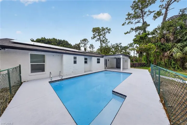 Rectangular swimming pool with integrated steps and metal handrails