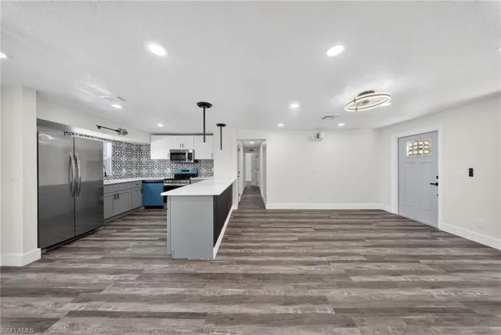 Open-concept living space featuring wood-finish flooring and recessed lighting