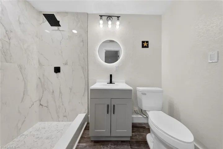 Shower with large format marble-look tile surround and black matte fixtures