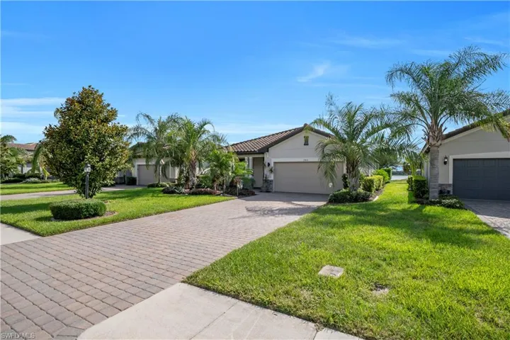 Paver driveway leading to a single-story residence with a two-car garage