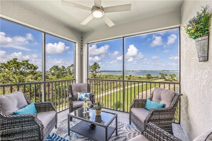 Sunroom / solarium featuring a water view and ceiling fan