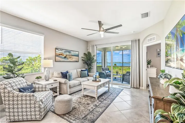 Living room with ceiling fan and light tile patterned floors