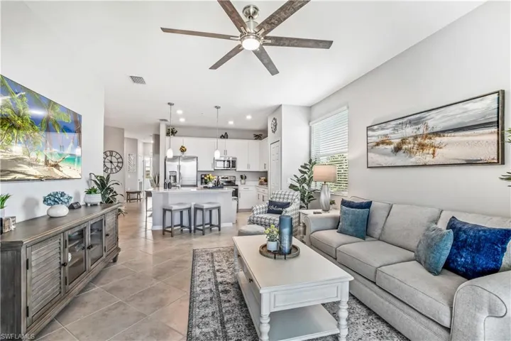 Living room with ceiling fan and light tile patterned floors