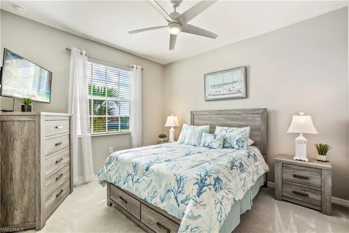 Bedroom with light colored carpet and ceiling fan