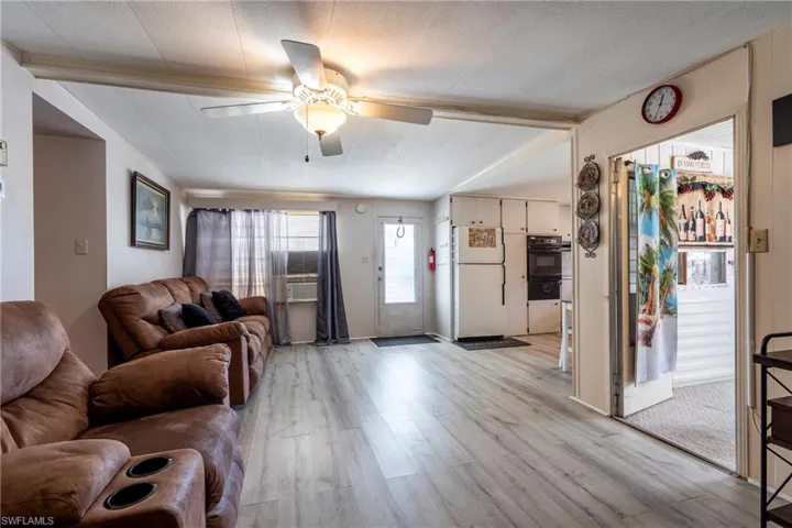 Living area with light wood-style vinyl floors and ceiling fan